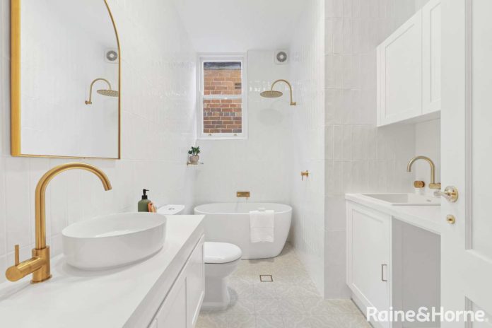 Homely - White tiled bathroom with gold faucets