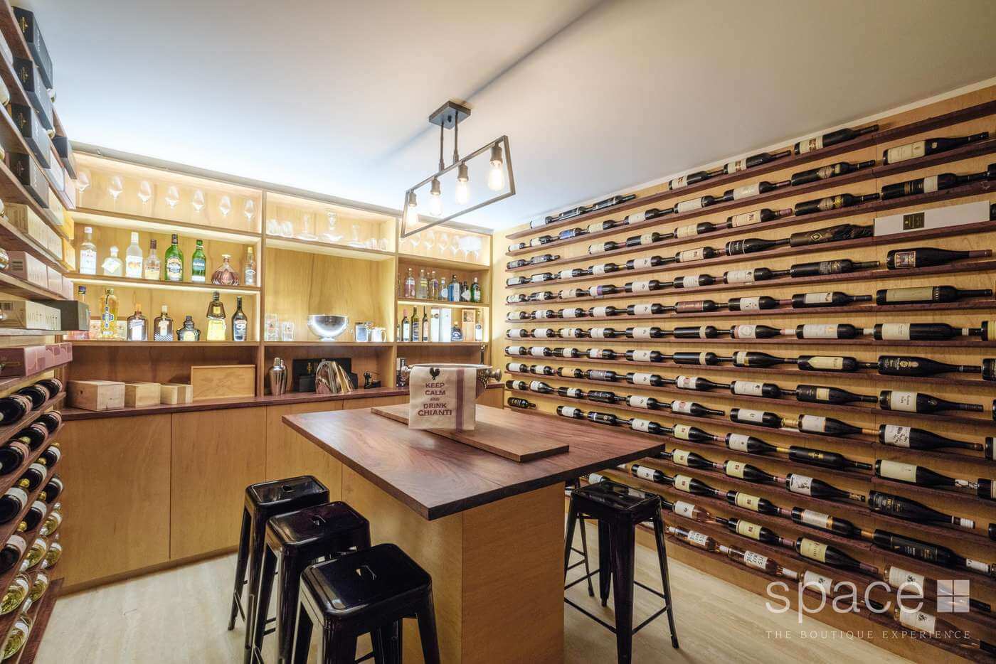 Modern basement wine cellar with table and chairs, stocked bar and wine racks