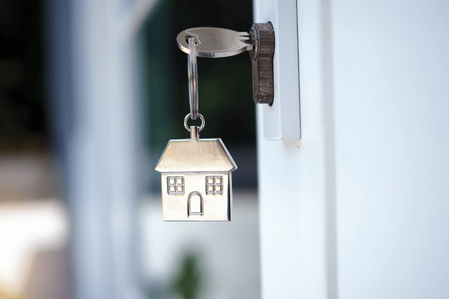 Little silver house hanging off key in door