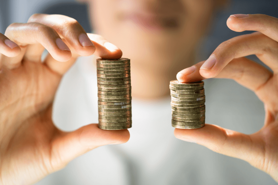 Two different sized stacks of coins being held by someone