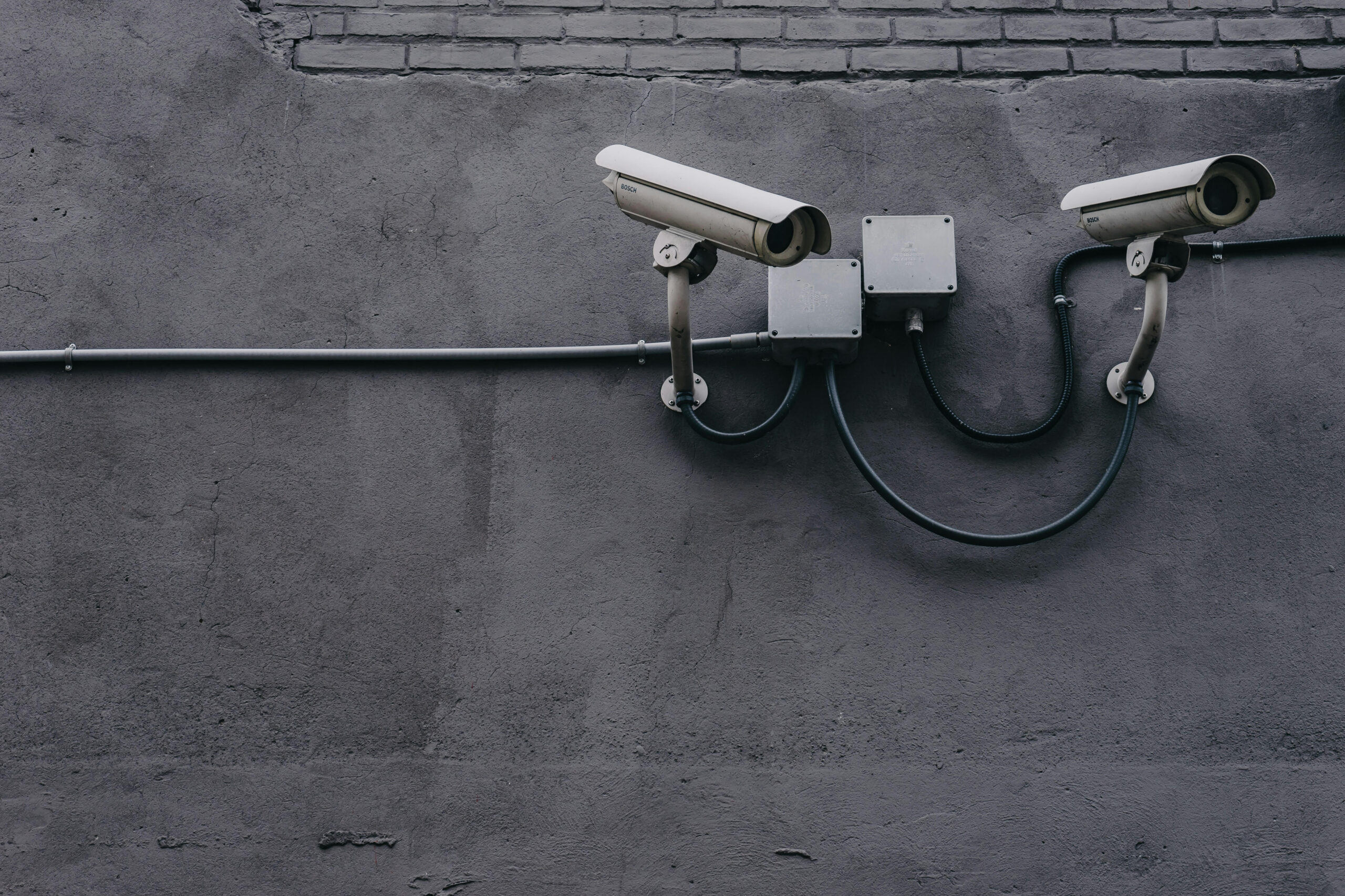 Security cameras hanging off of wall